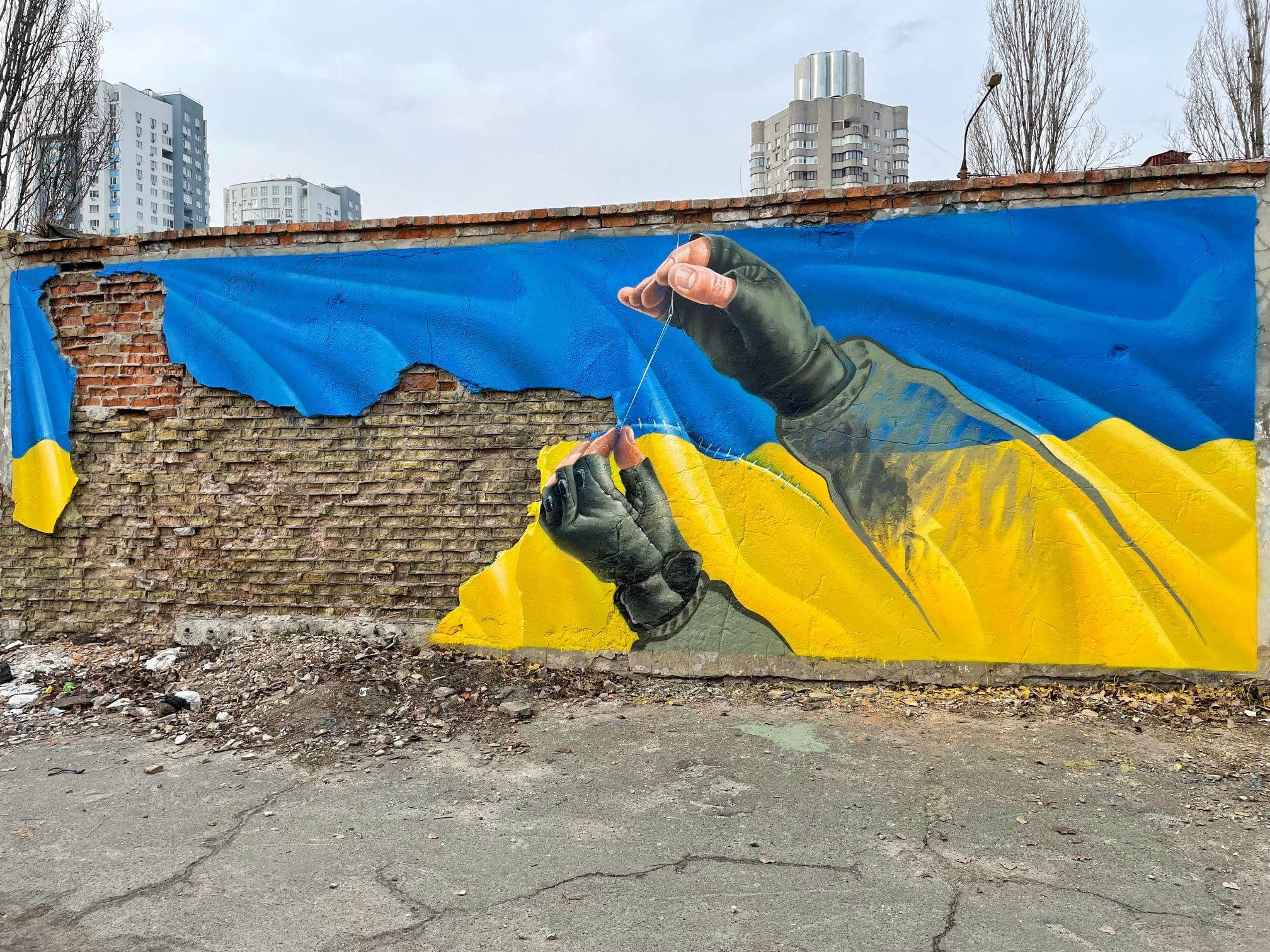 Руки, що зшивають Україну: Саша Корбан створив патріотичний мурал на Оболоні