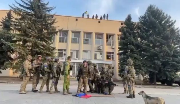 Бійці ЗСУ під вигуки «Слава Україні!» скидають ворожі триколори з даху адміністративної будівлі.