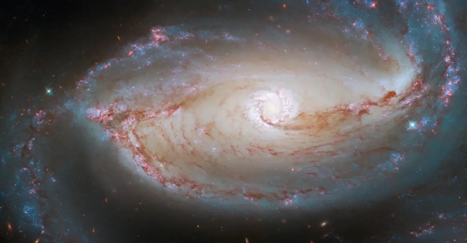 Нова місія NASA вивчатиме ультрафіолетове небо, зірки та вибухи зірок. (На цьому зображенні показано серце спіральної галактики NGC 1097 із смугою, яку зафіксувано космічним телескопом Хаббла).